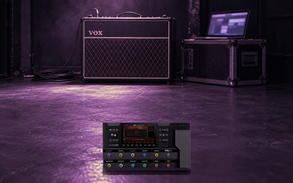 A Helix Stadium on a rehearsal room floor beside a combo amp and a laptop